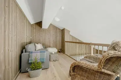 a room with a couch and chairs on a balcony at Cosy Apartment With Ski Inout In Hafjell in Øyer