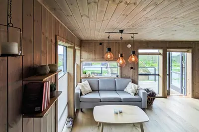 a living room with a couch and a table at Spacious Familyabin With A View On Norefjell in Noresund