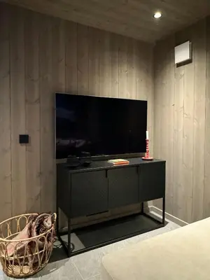 a living room with a television and a chair at Modern Family Cabin In Norefjell Ski-Inout in Surteberg
