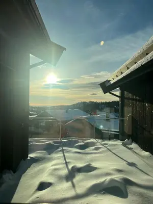 a snow covered balcony with the sun in the background at Modern Family Cabin In Norefjell Ski-Inout in Surteberg
