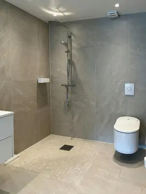 a bathroom with a shower and a toilet at Charming Seaside Cabin With Views Over The Water