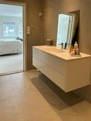 a bathroom with a sink and a mirror at Charming Seaside Cabin With Views Over The Water