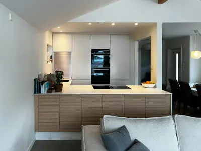 a kitchen with a couch and a stove top oven at Charming Seaside Cabin With Views Over The Water