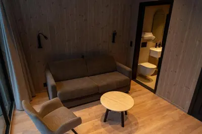a living room with a couch and a table and a chair at Kulleseidkanalen gjestehamn in Bømlo