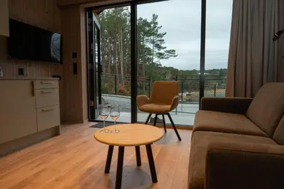 a living room with a couch and a table with wine glasses at Kulleseidkanalen gjestehamn in Bømlo