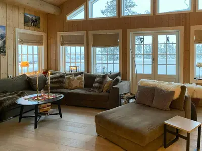 a living room with a couch and a table at Mountain Cabin With Sauna, Jacuzzi And Views in Nord Torpa
