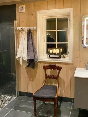 a wooden chair in a bathroom with a window at Mountain Cabin With Sauna, Jacuzzi And Views in Nord Torpa