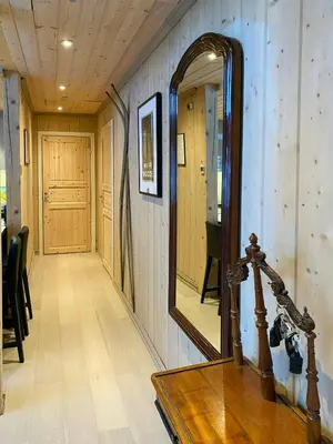 a mirror on the wall of a hallway with a table at Mountain Cabin With Sauna, Jacuzzi And Views in Nord Torpa