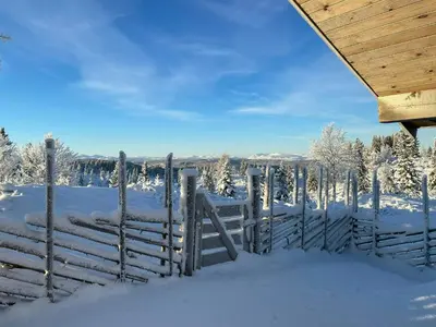 a fence covered in snow with snow covered trees at Family Cabin With Views In Sør-Fron in Sør-Fron