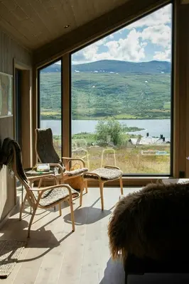 a room with two chairs and a large window at Modern Mountain Cabin With Nature In Valdres in Løken