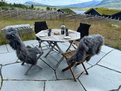 two stuffed dogs sitting on chairs around a table at Modern Mountain Cabin With Nature In Valdres in Løken