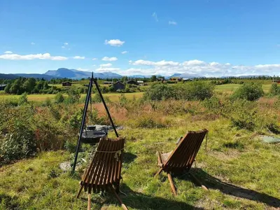 two wooden chairs sitting in a field of grass at Mountain Cabin With Wood-Fired Sauna And A View in Golsfjellet