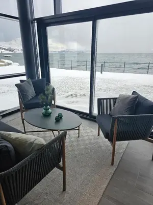 a living room with a couch and chairs and a table at Stor og ny leilighet med fjordutsikt in Sande