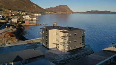 a building in the middle of a body of water at Stor og ny leilighet med fjordutsikt in Sande