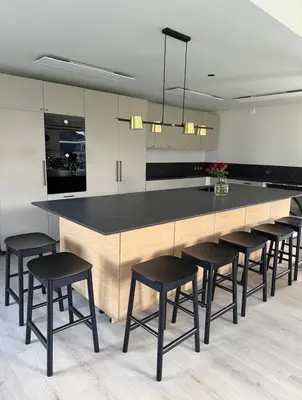 a kitchen with a large island with black bar stools at Lodge Orkanger - Spacious Comfort - Designed for family moments in Orkanger