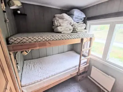 a small room with two bunk beds and a window at Hemsedal - 5 bedrooms in Fausko