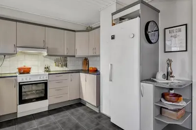 a kitchen with white cabinets and a white refrigerator at Utsikten in Trondheim