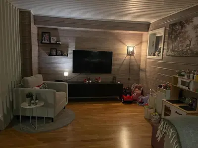 a living room with a couch and a television on a wall at Utsikten in Trondheim