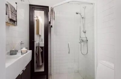 a white bathroom with a shower and a sink at Sentral leilighet Trondheim in Trondheim