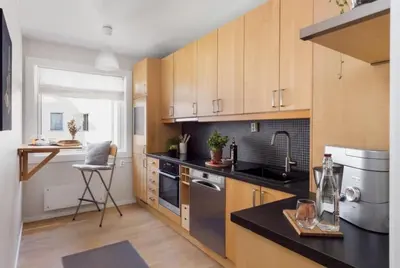 a kitchen with wooden cabinets and a black counter top at Sentral leilighet Trondheim in Trondheim