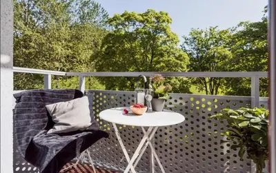 a white table and a chair on a balcony at Sentral leilighet Trondheim in Trondheim