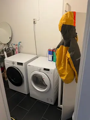 a laundry room with a washing machine and a washer at Ski VM in Trondheim