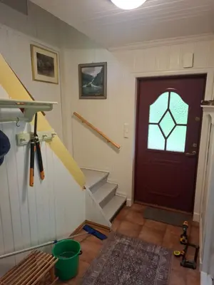 a room with a red door and stairs with a window at Jordamorstova in Aurland