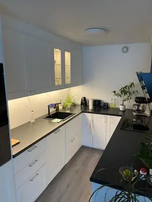 a kitchen with white cabinets and a black counter top at Trondheim in Trondheim