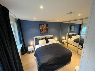 a bedroom with a large bed and a mirror at Apartment by Torgalmenningen in Bergen