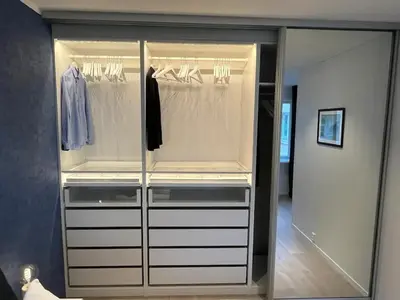 a closet with white drawers and a glass door at Apartment by Torgalmenningen in Bergen
