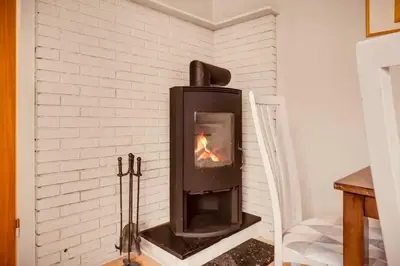 a fireplace in a room with a white brick wall at Live the history in Bergens heart - Stay unique in Bergen