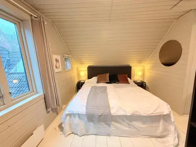 a bedroom with a bed in a room with a window at Live the history in Bergens heart - Stay unique in Bergen