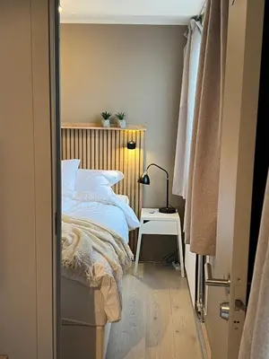 a bedroom with a bed and a lamp on a table at Voss Apartment in Oppheim Resort, pool and view in Vossevangen