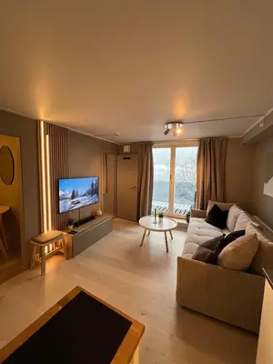 a living room with a couch and a tv at Voss Apartment in Oppheim Resort, pool and view in Vossevangen