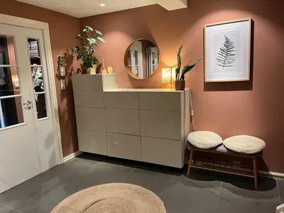 a bathroom with a mirror and a dresser with two stools at Enebolig til utleie in Trondheim