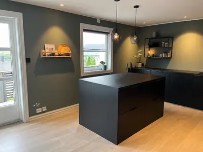 a kitchen with a black island in a room at Enebolig til utleie in Trondheim