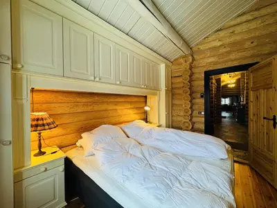 a bedroom with a bed with a wooden wall at Large, cozy, and spacious cabin in Geilo in Geilo