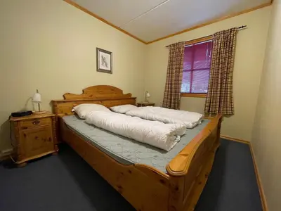 a bedroom with a wooden bed and a window at Family-Friendly Stay Near Ski Trails! in Beitostøl