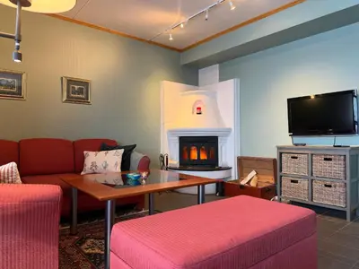 a living room with a couch and a fireplace at Homey Apartment Steps From Dining And Activities! in Beitostøl
