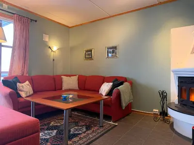 a living room with a red couch and a table at Homey Apartment Steps From Dining And Activities! in Beitostøl