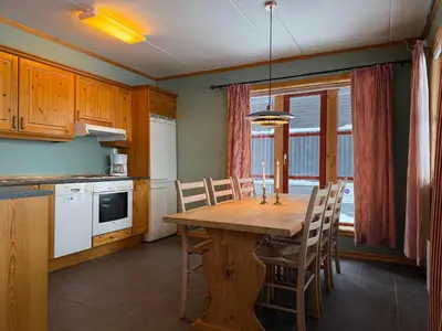 a kitchen and dining room with a wooden table and chairs at Homey Apartment Steps From Dining And Activities! in Beitostøl