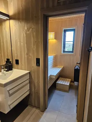 a bathroom with a sink and a bench next to a window at Varden in Sør-Fron