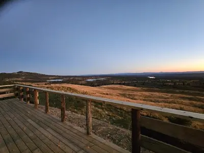 a wooden deck with a view of a field at Utsikten in Sør-Fron