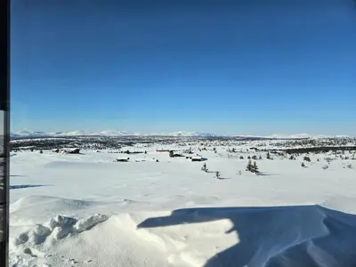 a shadow of a person standing in a snow covered field at Utsikten in Sør-Fron