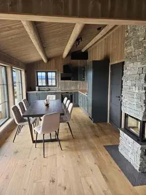 a kitchen and dining room with a table and a fireplace at Utsikten in Sør-Fron