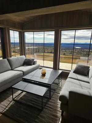 a living room with a couch and a table and windows at Utsikten in Sør-Fron