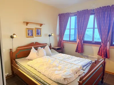 a bedroom with a large bed with purple curtains at Central Apartment With Garage, Views, Ski In And Out in Beitostøl