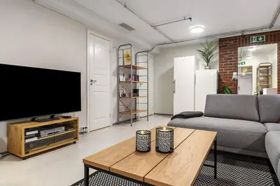 a living room with a couch and a tv at 1-roms leiligheter med felles bad, stue og kjøkken in Steinkjer