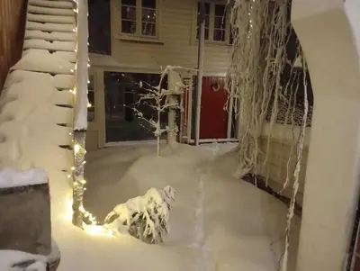 a yard covered in snow with a house at Nice two-floor home by Gamle bybro in Trondheim