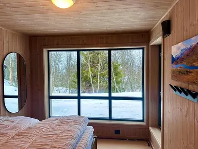 a bedroom with a large window and a bed at Immaculate Cabin in the Heart of Beitostølen in Beitostøl